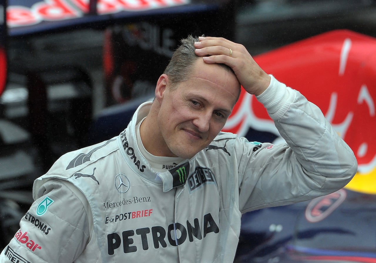 (FILES) In this file photo taken on November 25, 2012 then German Formula One driver Michael Schumacher gestures at the end of Brazil's F1 Grand Prix at the Interlagos racetrack in Sao Paulo, Brazil. German prosecutors said on September 25, 2024 they were bringing charges against three men arrested this year over a blackmail plot targeting the family of Formula One legend Michael Schumacher. They said the chief suspect, a 53-year-old man from the western German city of Wuppertal, had threatened to release private photos and videos and demanded 15 million euros (USD 16.7 million) from Schumacher's family. These allegedly included images of the seven-time Formula One champion before and after the 2013 skiing accident in the French Alps which left him with a serious brain injury. (Photo by Yasuyoshi CHIBA / AFP)