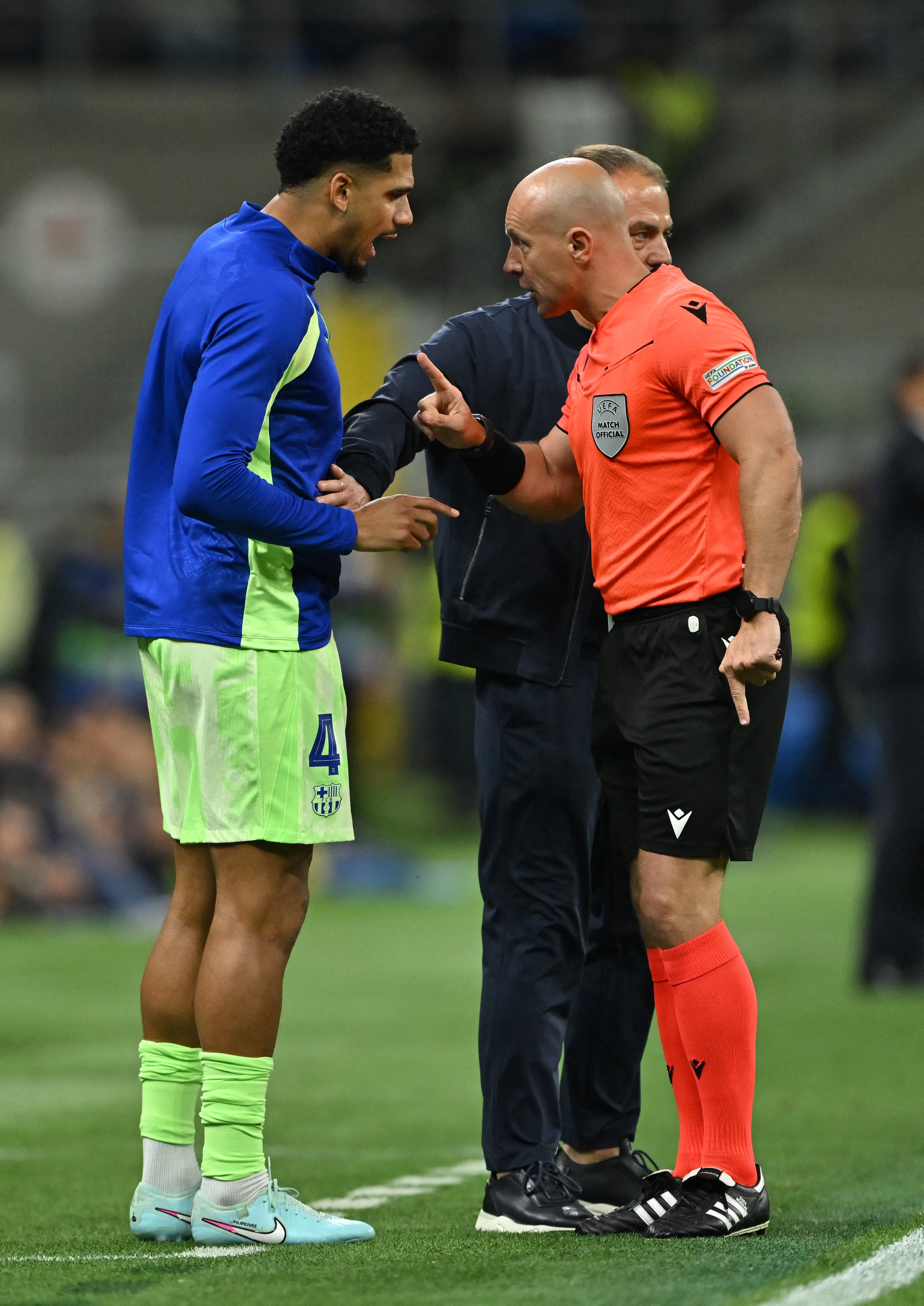 MILAN, ITALY - MAY 06: Hansi Flick, Head Coach of FC Barcelona, holds back Ronald Araujo of FC Barcelona as he speaks to referee Szymon Marciniak during the UEFA Champions League 2024/25 Semi Final Second Leg match between FC Internazionale Milano and FC Barcelona at Giuseppe Meazza Stadium on May 06, 2025 in Milan, Italy. (Photo by Dan Mullan/Getty Images) (Photo by Dan Mullan / GETTY IMAGES EUROPE / Getty Images via AFP)