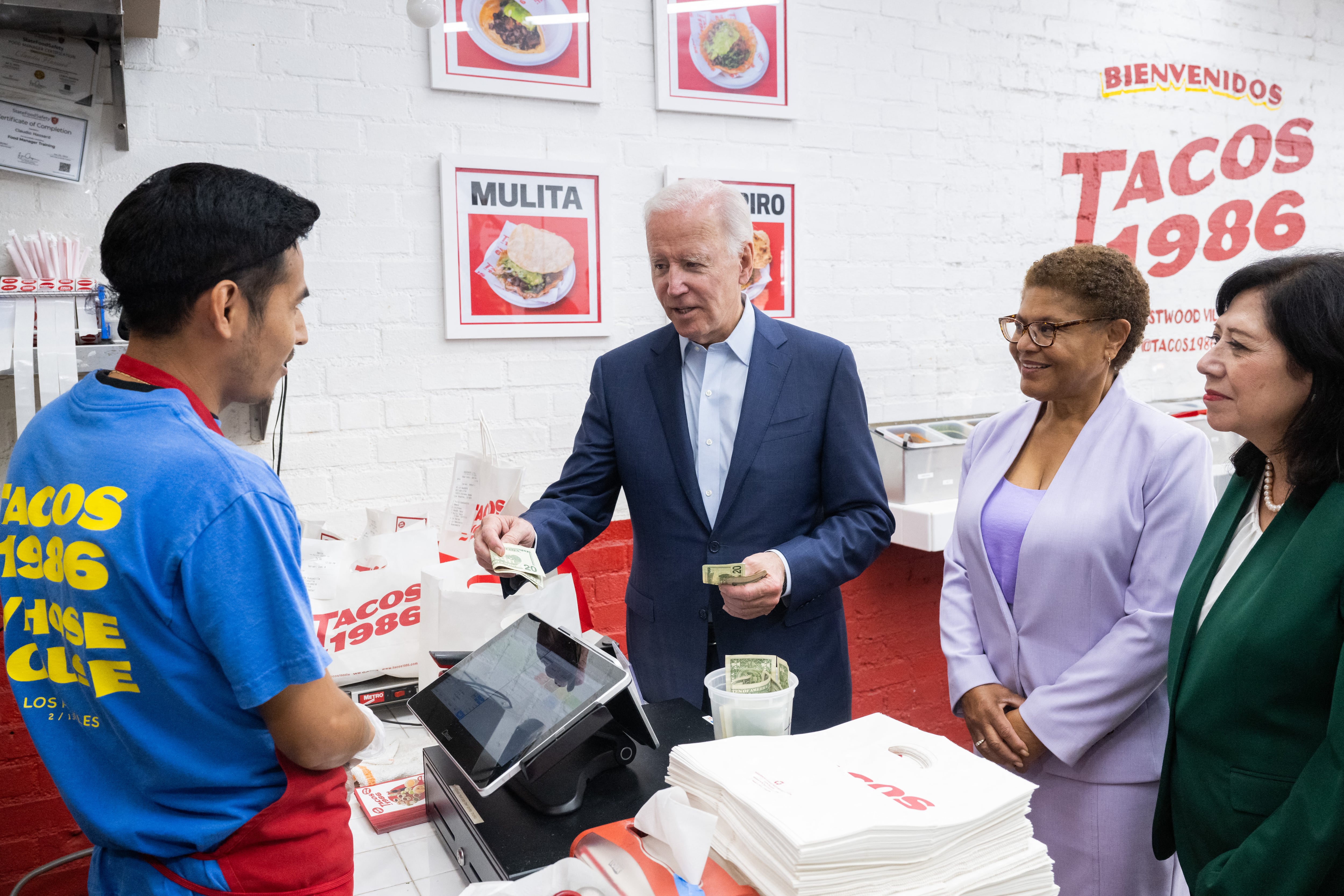 El presidente de los Estados Unidos, Joe Biden, hace una visita sorpresa para recoger el almuerzo junto con la representante de los Estados Unidos, Karen Bass (centro), demócrata de California, y la supervisora ​​del condado de Los Ángeles, Hilda Solis (derecha), en Tacos 1986 en Los Ángeles, California, el 13 de octubre de 2022. ( Foto de SAUL LOEB / AFP)