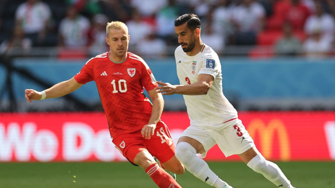 Soccer Football - FIFA World Cup Qatar 2022 - Group B - Wales v Iran - Ahmad Bin Ali Stadium, Al Rayyan, Qatar - November 25, 2022 Iran's Ehsan Hajsafi in action with Wales' Aaron Ramsey REUTERS/Carl Recine