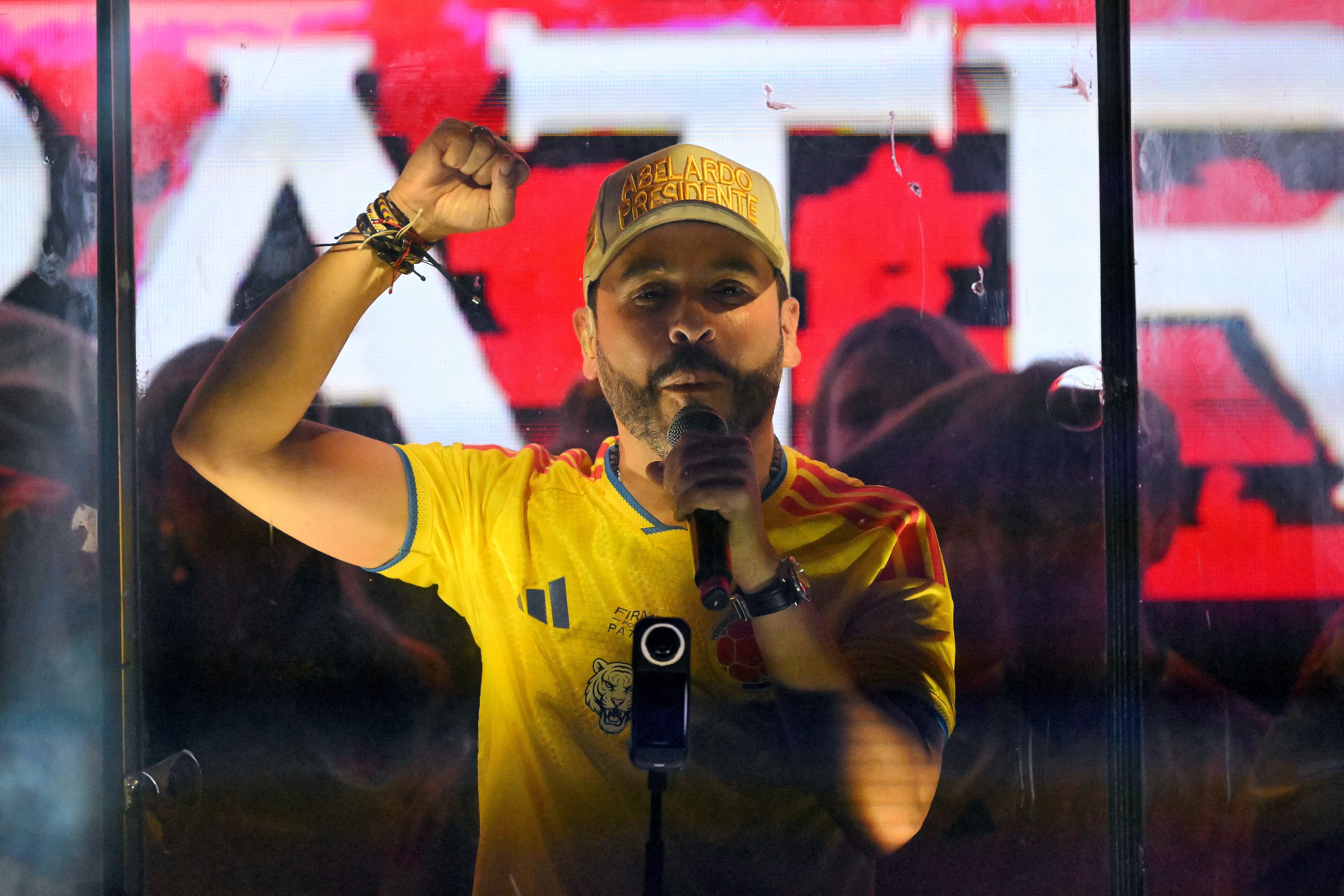 Colombia's presidential candidate Abelardo de la Espriella, of the Salvadores de la Patria movement, speaks to supporters behind bulletproof glass after a quick count of votes in the presidential election at the Ventana al Mundo monument in Barranquilla, Colombia, on May 31, 2026. Colombia's presidential election appeared headed for a runoff between leftist Ivan Cepeda and hard-right Abelardo de la Espriella on May 31, presenting voters with a stark choice between peace talks and a militarized crackdown. (Photo by Rodrigo BUENDIA / AFP)