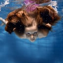 Niña, (10-12), nadar bajo el agua, con, pelo que fluye, retrato