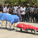 Los líderes políticos oran frente a los dos cuerpos de los legisladores locales, incluida Amina Mohamed Abdi, después de ser trasladados en avión desde Beledweyne, en el Aeropuerto Internacional Aden Adde en Mogadiscio, Somalia, el 24 de marzo de 2022. - El número de muertos por ataques gemelos en el centro de Somalia el 24 de marzo de 2022. La noche del 23 de marzo de 2022 superó los 30, dijo a la AFP el jefe de policía del distrito de Beledweyne el 24 de marzo de 2022, y el grupo insurgente Al-Shabaab dijo que estaba atacando a los políticos antes de las elecciones. (Foto de Hassan Ali ELMI / AFP)