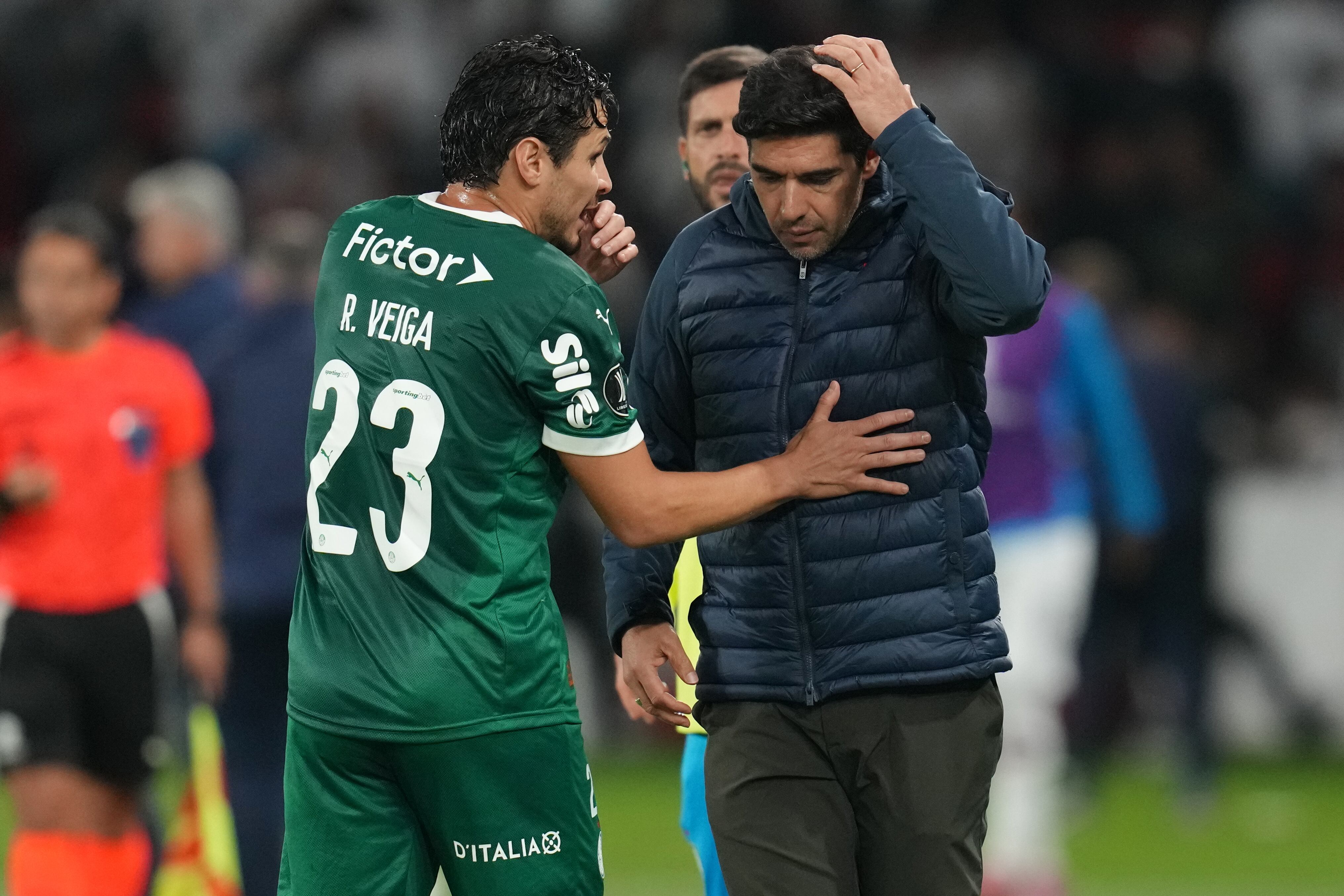 Raphael Veiga of Brazil's Palmeiras, left, talks with his coach Abel Ferreira during a Copa Libertadores semifinal first leg soccer match against Ecuador's Liga Deportiva Universitaria in Quito, Ecuador, Thursday, Oct. 23, 2025. (AP Photo/Dolores Ochoa)