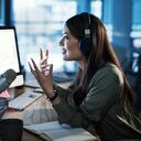 Foto de una mujer haciendo una transmisión mientras está sentada en una oficina por la noche