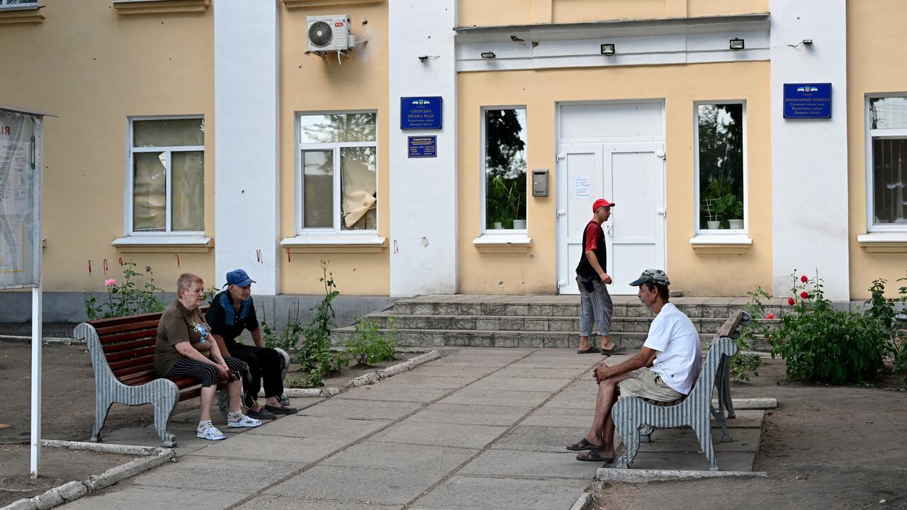 Pensioners wait outside Oschadbank to receive pension money in Siversk, in Donetsk Oblast, eastern Ukraine, on July 8, 2022, amid the Russian invasion of Ukraine. (Photo by MIGUEL MEDINA / AFP)
