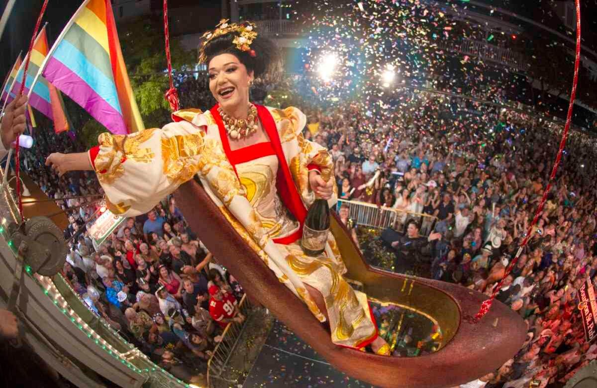 Con una botella en su mano izquierda, el imitador femenino Gary Marion, conocido como “Sushi”, se eleva unos metros del suelo sobre la calle Duval, en la calurosa Key West— ciudad de Florida—, sentado en una réplica enorme de un zapato de tacón alto de mujer el martes 31 de diciembre de 2019.  El Red Shoe Drop o caída de zapatos rojos, en español, es uno de los  despegues fuera de ritmo de Key West en el Times Square de Nueva York para celebrar el comienzo de 2020. Foto de Andy Newman/Florida Keys News Bureau vía AP. 
