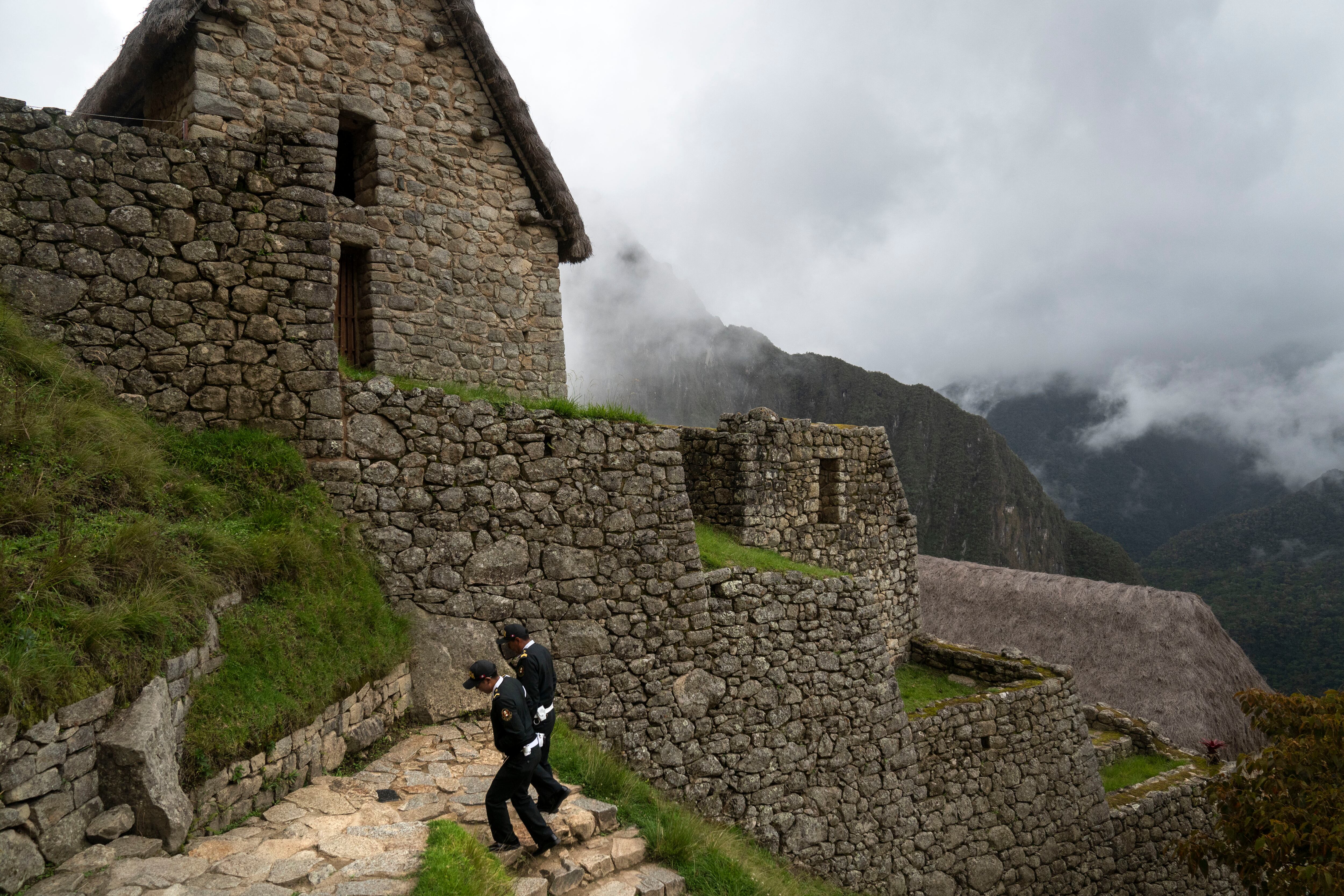 Dos agentes de policía caminan por las mundialmente famosas ruinas de Machu Picchu, ahora cerradas, en Machu Picchu, Perú