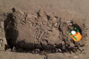 Un arqueólogo excava en la tumba de una momia prehispánica descubierta en una cima cercana a un campo de fútbol de un popular club peruano en el municipio de El Rimac de Lima, Perú, el jueves 15 de junio de 2023. (AP Foto/Martín Mejía)
