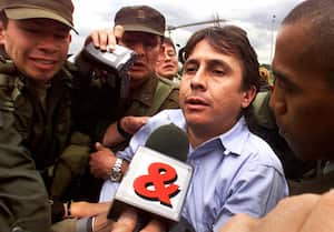 (FILES) This 13 October, 1999 file photo shows Colombian drug trafficker Fabio Ochoa (C) being escorted by police as he arrives in Bogota shortly after his capture along with another 29 narco-smugglers by Colombian authorities as part of a massive international sting operation code-named "Operation Millennium"involving the US, Mexico and Ecuador. A Miami court 26 August, 2003 sentenced Ochoa to 30 years in prison after a jury in May, 2003 found the former Medellin drug cartel kingpin guilty of involvement in a major cocaine smuggling ring. He sat motionless, his eyes closed, as Judge K. Michael Moore sentenced him to 365 months in prison and a 25,000 USD fine for his participation in the drug smuggling ring that shipped about 30 tons of cocaine a month to the United States in the late 1990s. AFP PHOTO/Pedro UGARTE (Photo by PEDRO UGARTE / AFP)