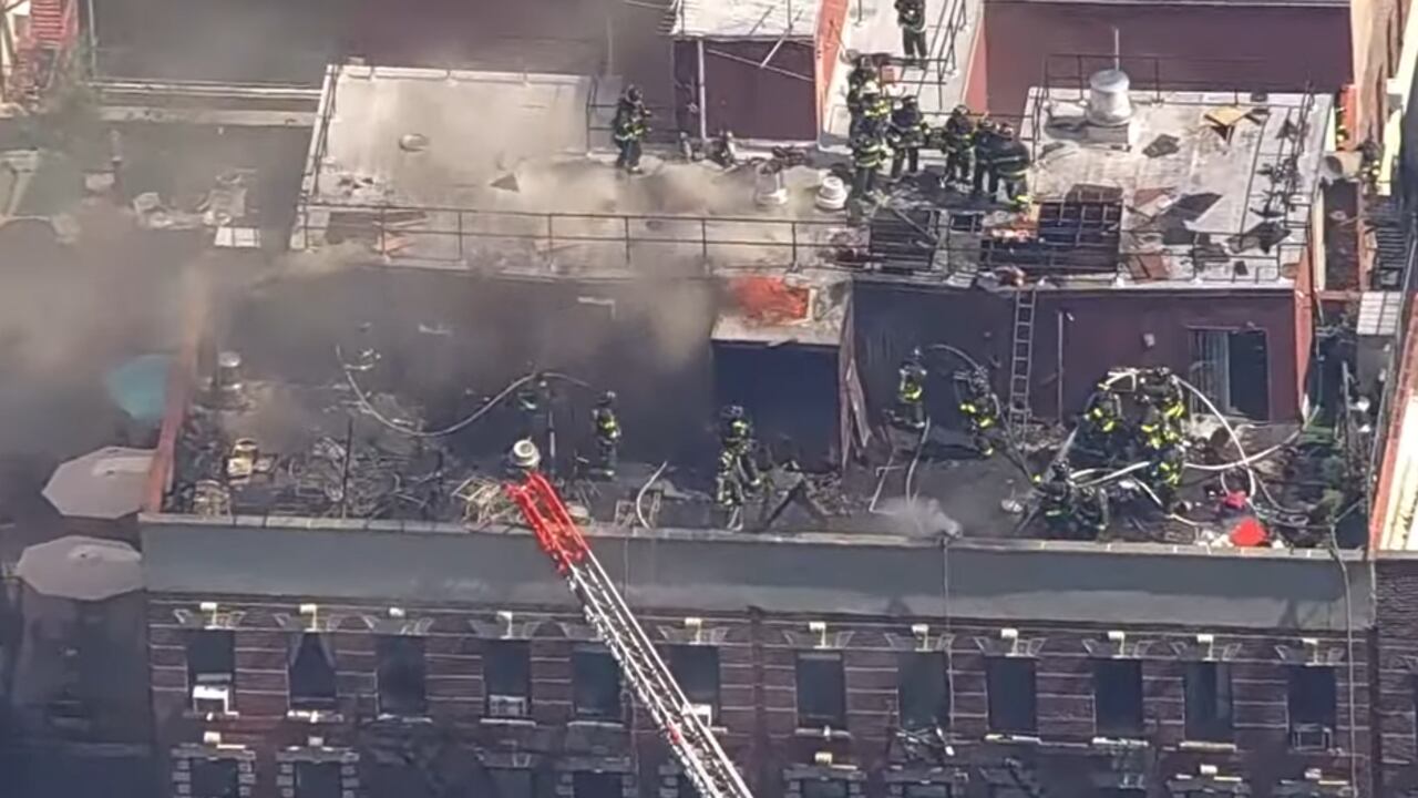 Incendio en azotea de edificio en Manhattan con gran despliegue de bomberos y densa nube de humo.