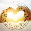 Las manos de las mujeres y los hombres tienen forma de corazón con la luz del sol que pasa por las manos tienen símbolos astrológicos. Foto: Getty Images