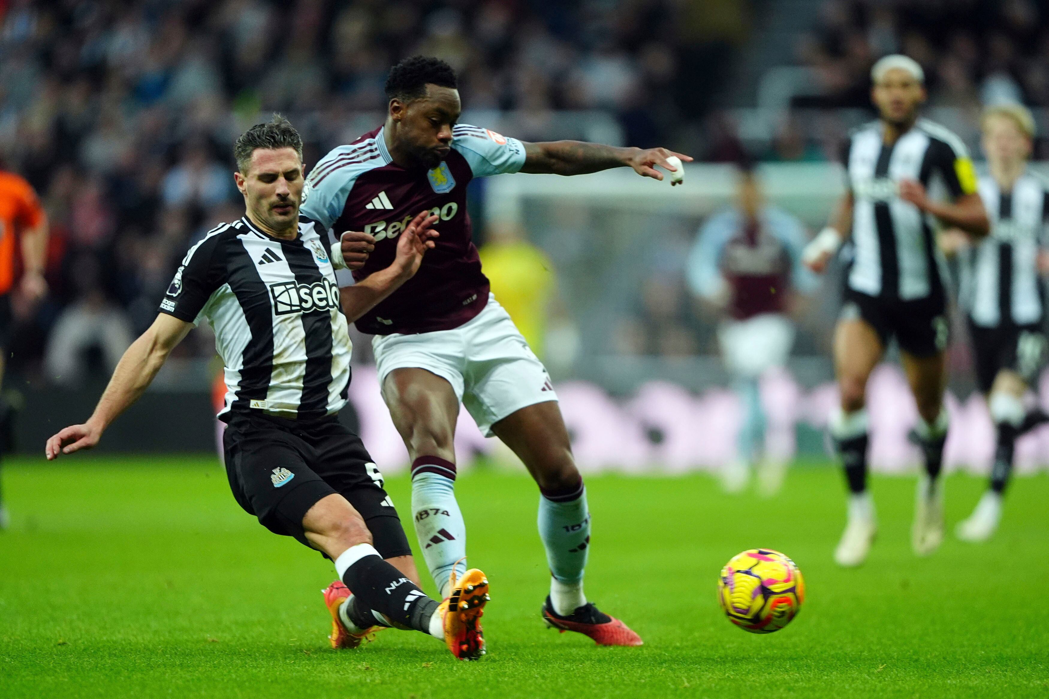 Newcastle United's Fabian Schar, left and Aston Villa's Jhon Duran vie for the ball, during the English Premier League soccer match between Newcastle United and Aston Villa at St. James' Park, in Newcastle upon Tyne, England, Thursday, Dec. 26, 2024. (Owen Humphreys/PA via AP)
