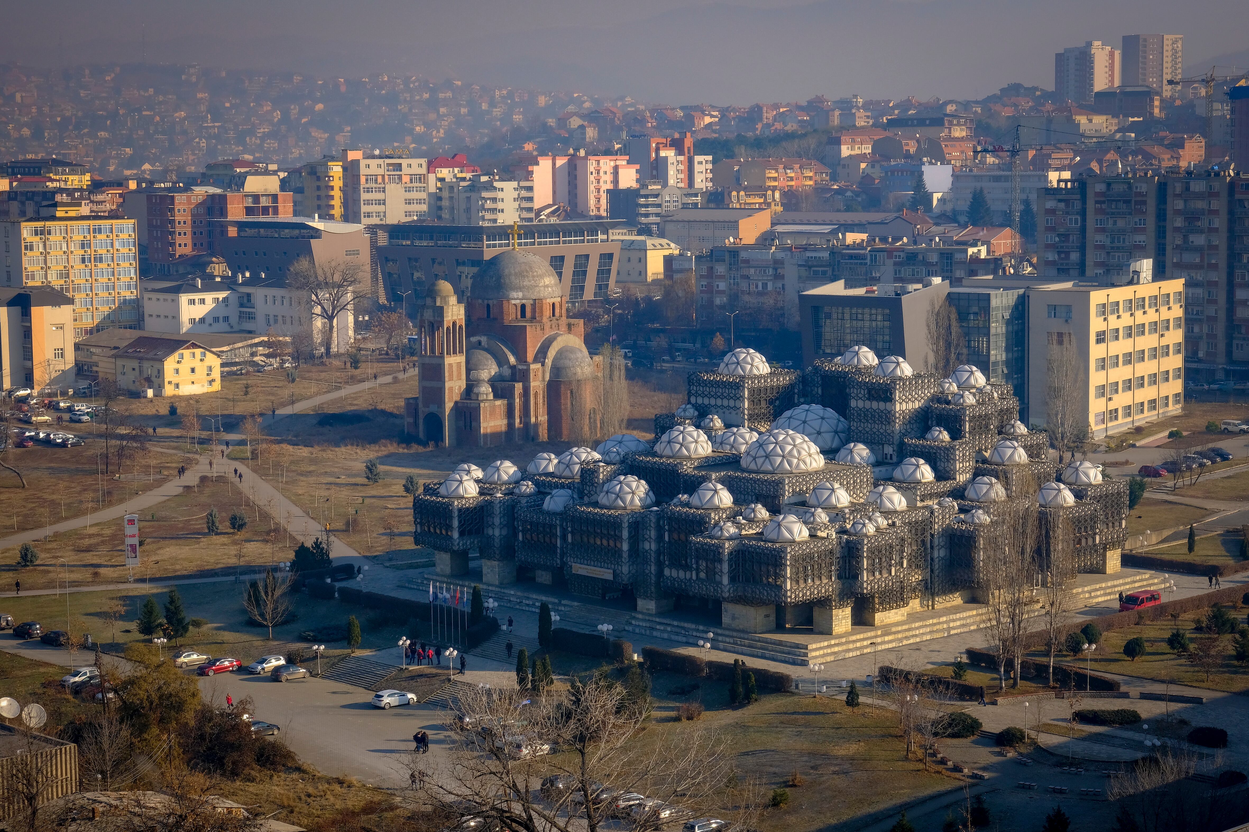 El horizonte de Pristina, incluyendo la Biblioteca Nacional de Kosovo PjetEr Bogdani y la incompleta Catedral Ortodoxa Serbia de Cristo Salvador, el 13 de diciembre de 2018, Pristina, Kosovo.