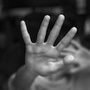 Muchacho que muestra el gesto de PARADA con la mano. Concepto de violencia doméstica y abuso infantil.