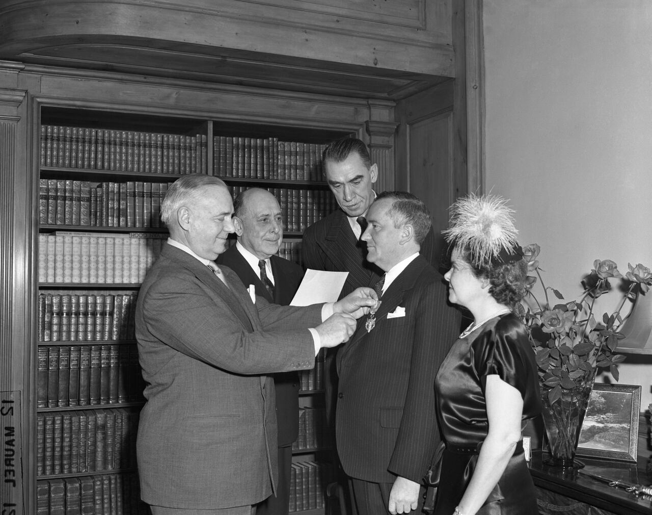 Gen. William J. Donovan, wartime OSS chief, presents medal for merit to Canadian-born Sir William S. Stephenson, who was director of British Security Coordination in the Western hemisphere from 1940-45. Looking on during ceremony in Sir Williams' suite at the Dorset Hotel are (left to right) Col. Edward G. Buxton, assistance director of OSS; Robert Sherwood, noted playwright, and Lady Stephenson.