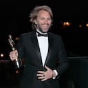 Florian Zeller smiles as he holds his Oscars statuette after winning the Best Adapted Screenplay for the 'The Father' at a screening of the Oscars on Monday April 26, 2021 in Paris, France. (AP Photo/Lewis Joly, Pool)
