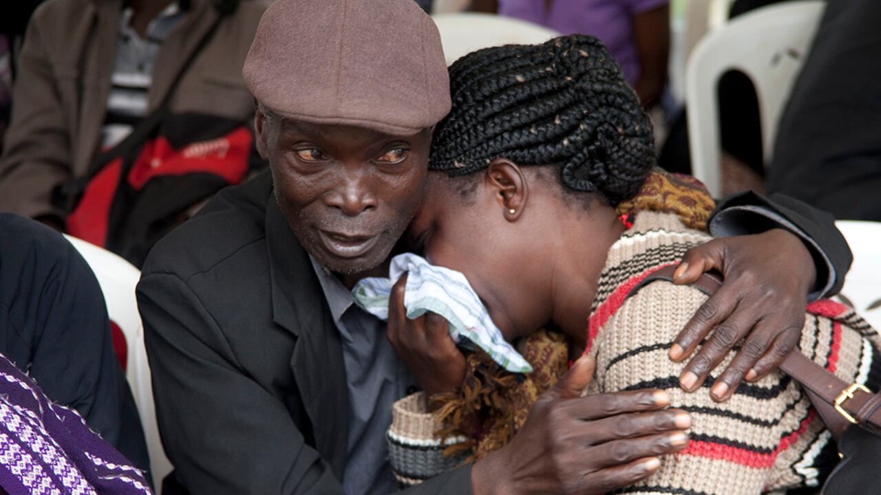 Un hombre reconforta a una mujer que acaba de reconocer el cuerpo de su pariente que perdió la vida en el ataque a la Universidad de Garissa.