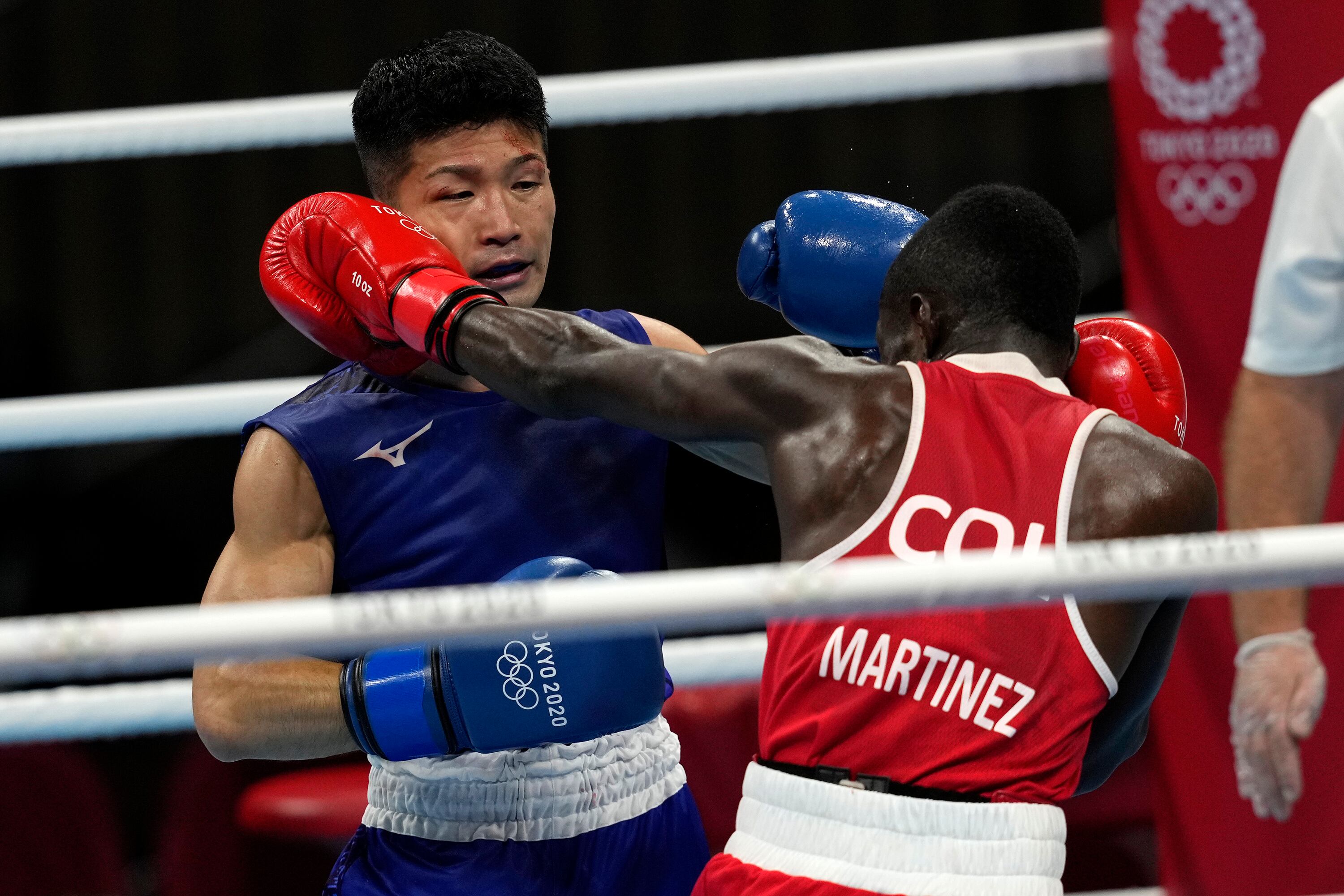 Colombia's Yuberjen Herney Martinez Rivas, right, exchanges punches with Japan's Ryomei Tanaka in their men's flyweight 52-kg quarterfinal boxing match at the 2020 Summer Olympics, Tuesday, Aug. 3, 2021, in Tokyo, Japan. (AP Photo/Themba Hadebe)