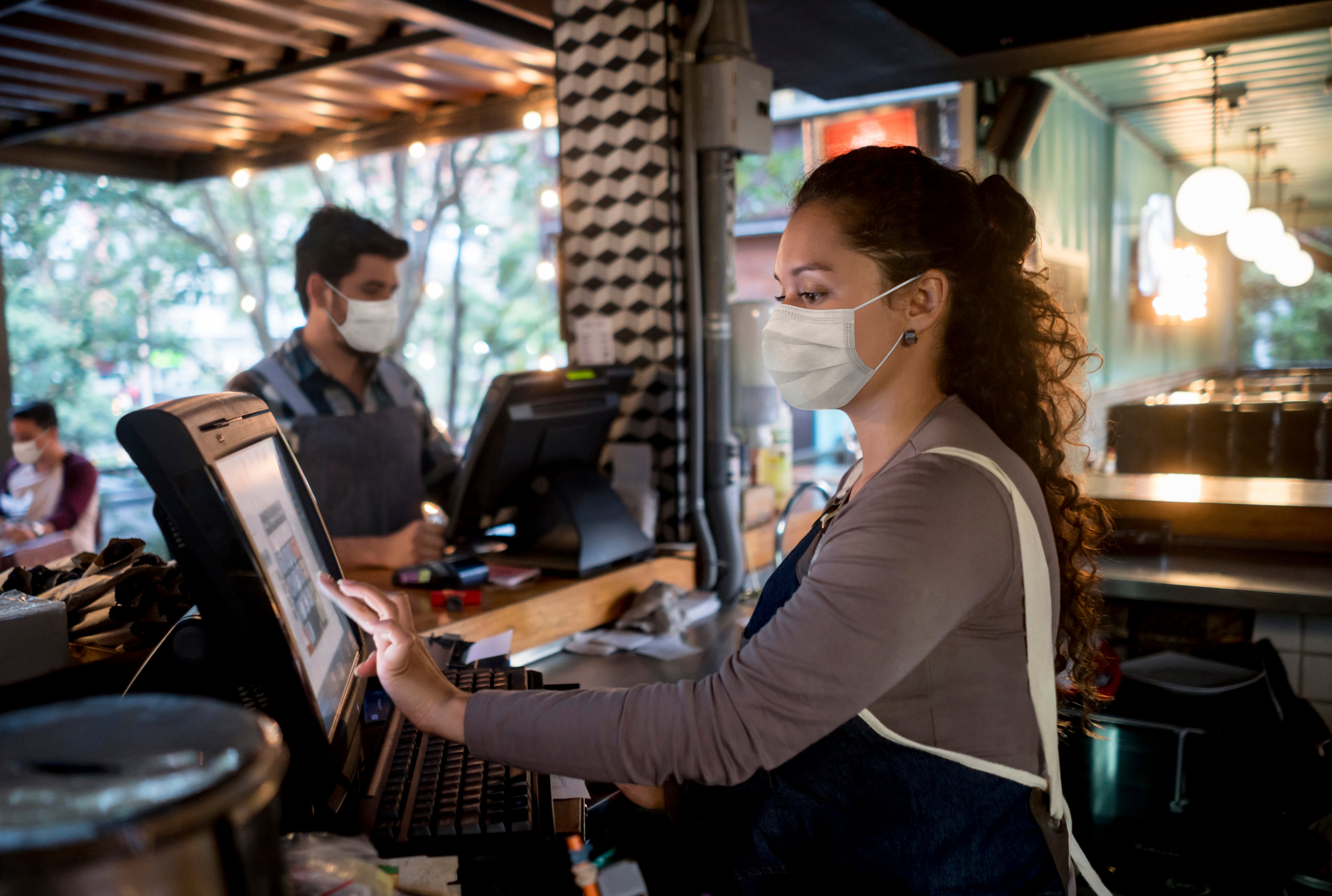 Retrato de una mujer que trabaja en el cajero de un restaurante con un tapabocas conceptos de ocupación del servicio de alimentos.