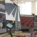 Close up stock image of an African American man working at a computer screen. He’s working on CAD software looking at the design of a solar panel array in CAD with data.