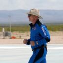 Jeff Bezos, founder of Amazon and space tourism company Blue Origin jogs onto the Blue Origin's New Shepard rocket landing pad to pose for photos at the spaceport near Van Horn, Texas, Tuesday, July 20, 2021. (AP Photo/Tony Gutierrez)