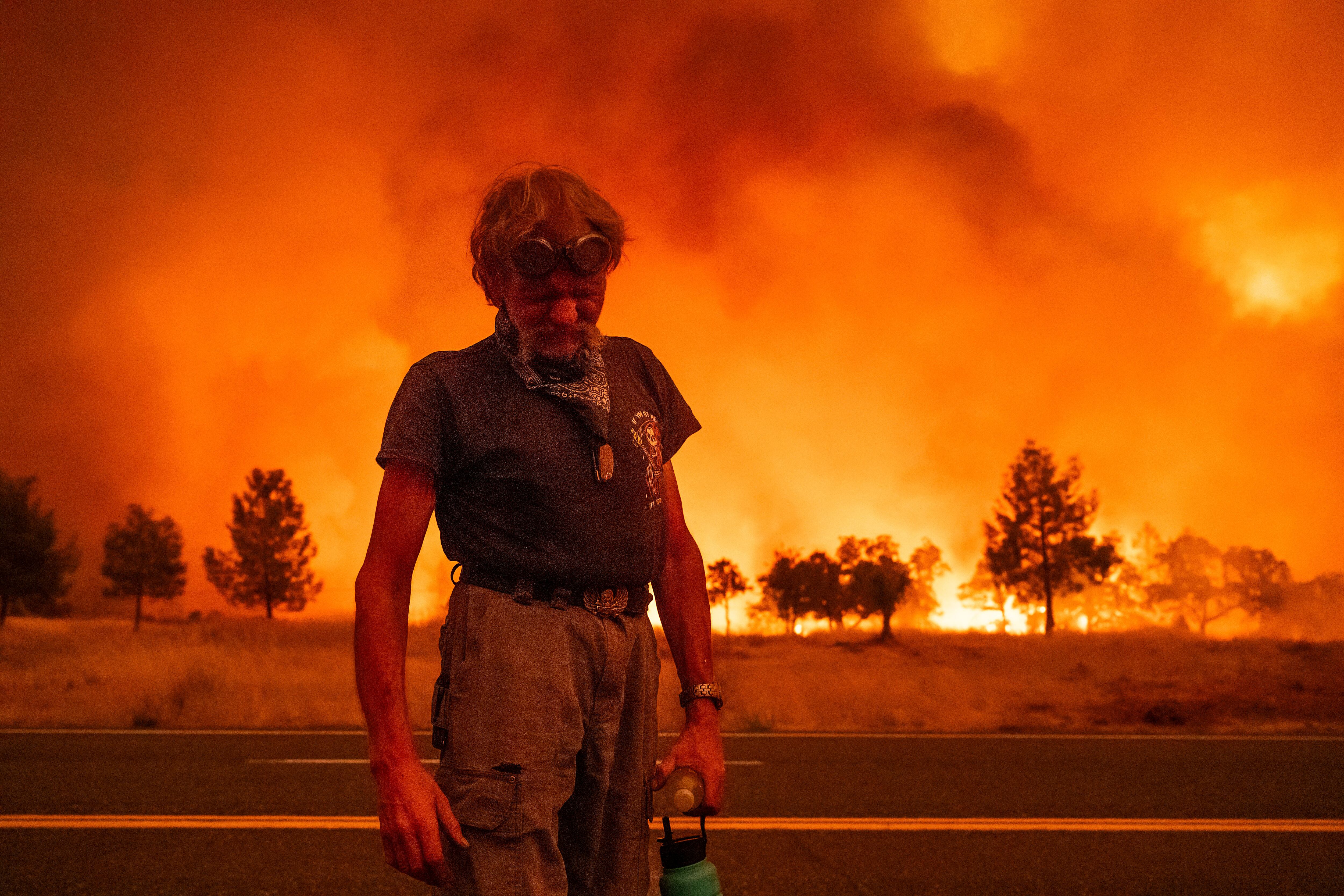 Grant Douglas hace una pausa mientras evacúa por el incendio de Park en la Autopista 36 cerca de Paynes Creek en el condado Tehama, California, el viernes 26 de julio de 2024. (AP Foto/Noah Berger)