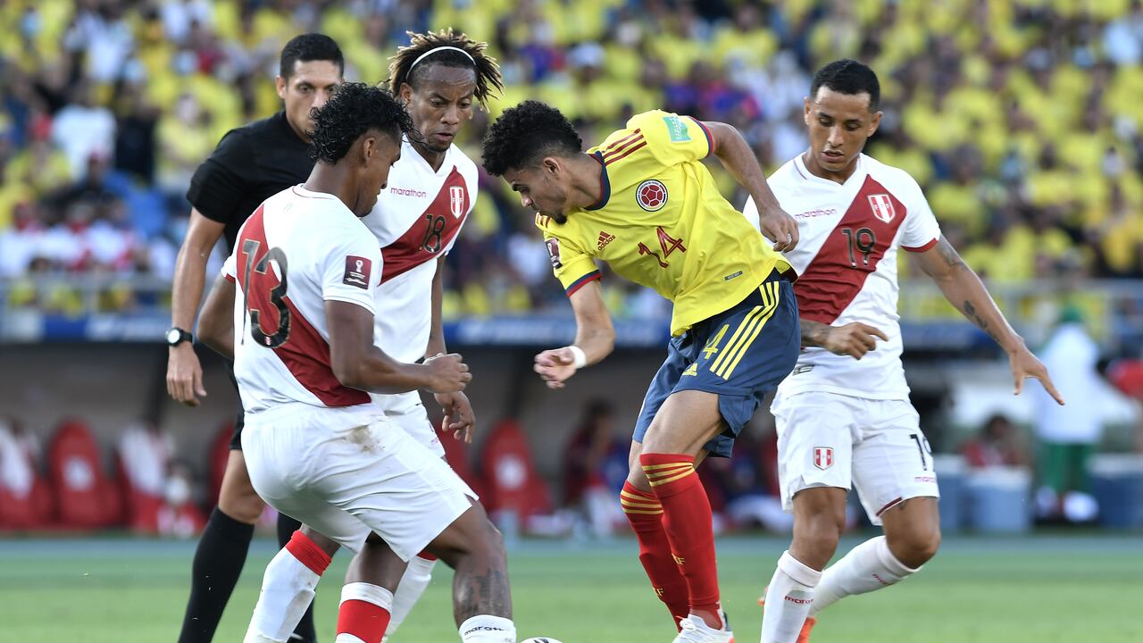 Luis Díaz enfrentando a tres jugadores de Perú en un partido de eliminatorias.