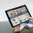 Vista posterior de la mujer madura haciendo compras en línea en el sitio web con tableta digital en casa. Vista superior de la mujer con el pelo rojo relajándose en el sofá mientras compra en línea en el sitio web de comercio electrónico. Vista posterior de la pantalla táctil de la mano de la niña mientras selecciona el producto en el portal de comercio electrónico.