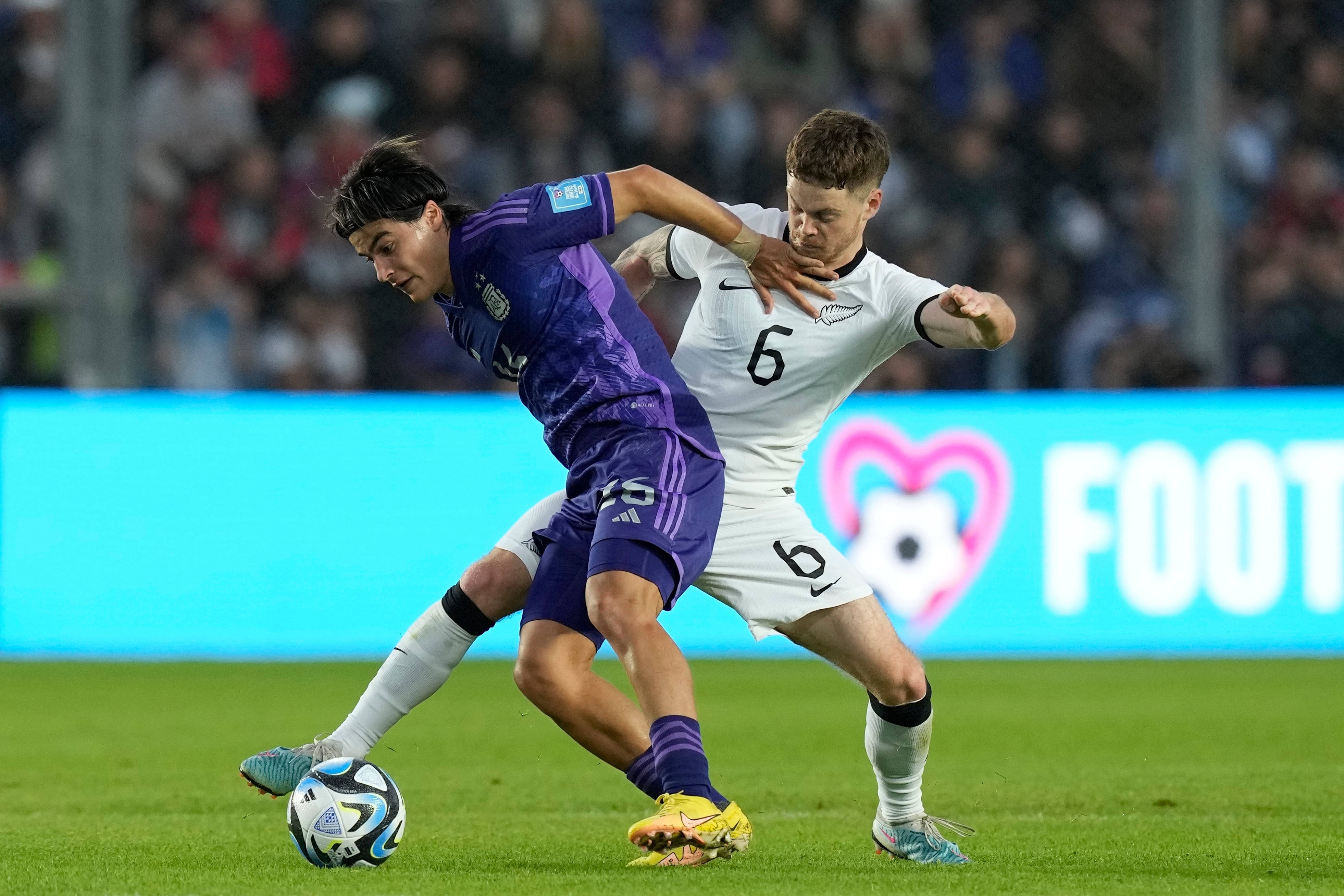 Argentina's Luka Romero, left, and New Zealand's Fin Conchie battle for the ball during a FIFA U-20 World Cup Group A soccer match at the San Juan stadium in San Juan, Argentina, Friday, May 26, 2023. (AP Photo/Natacha Pisarenko)