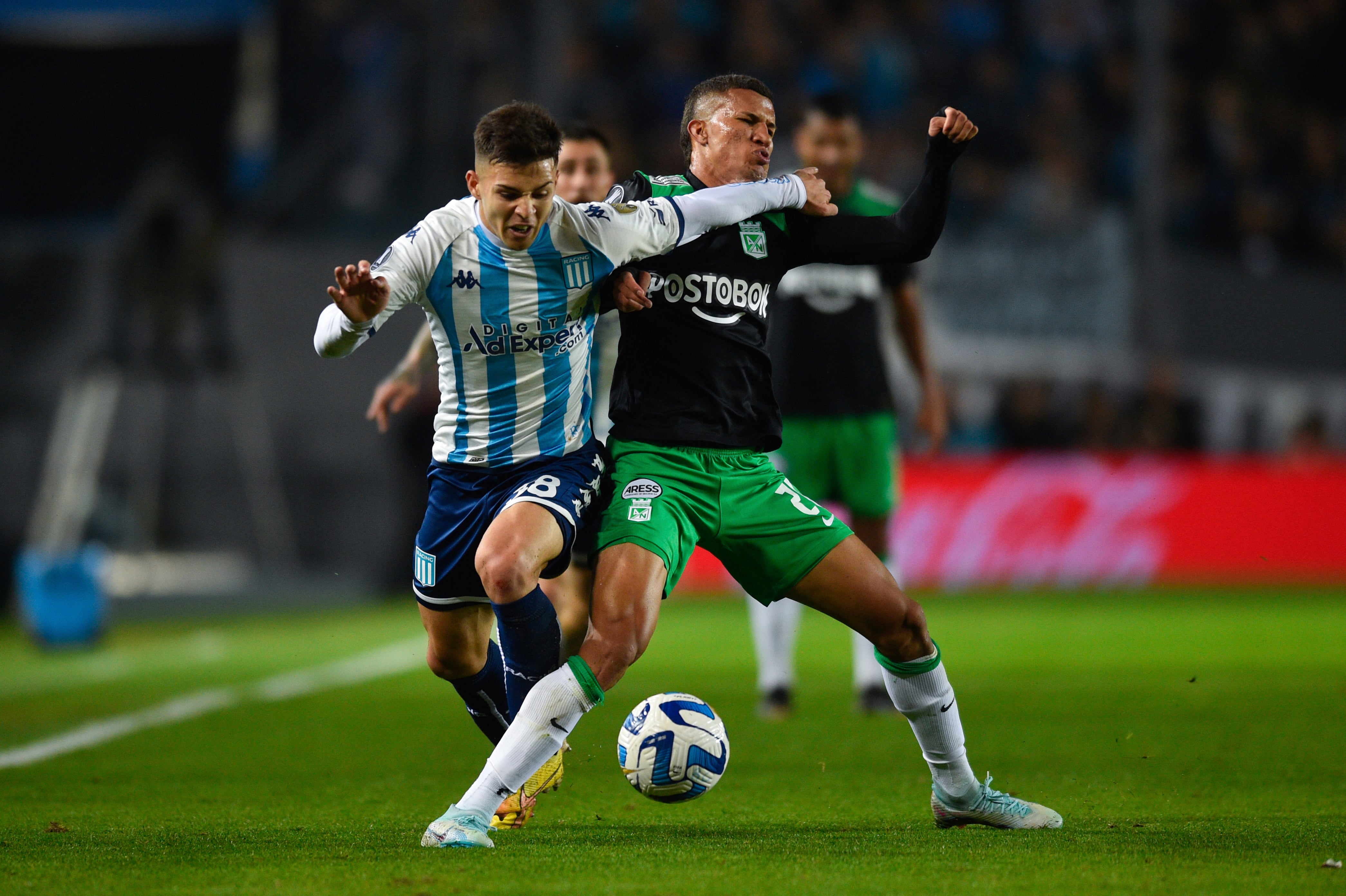 Nelson Deossa peleando un esférico con rival de Racing.