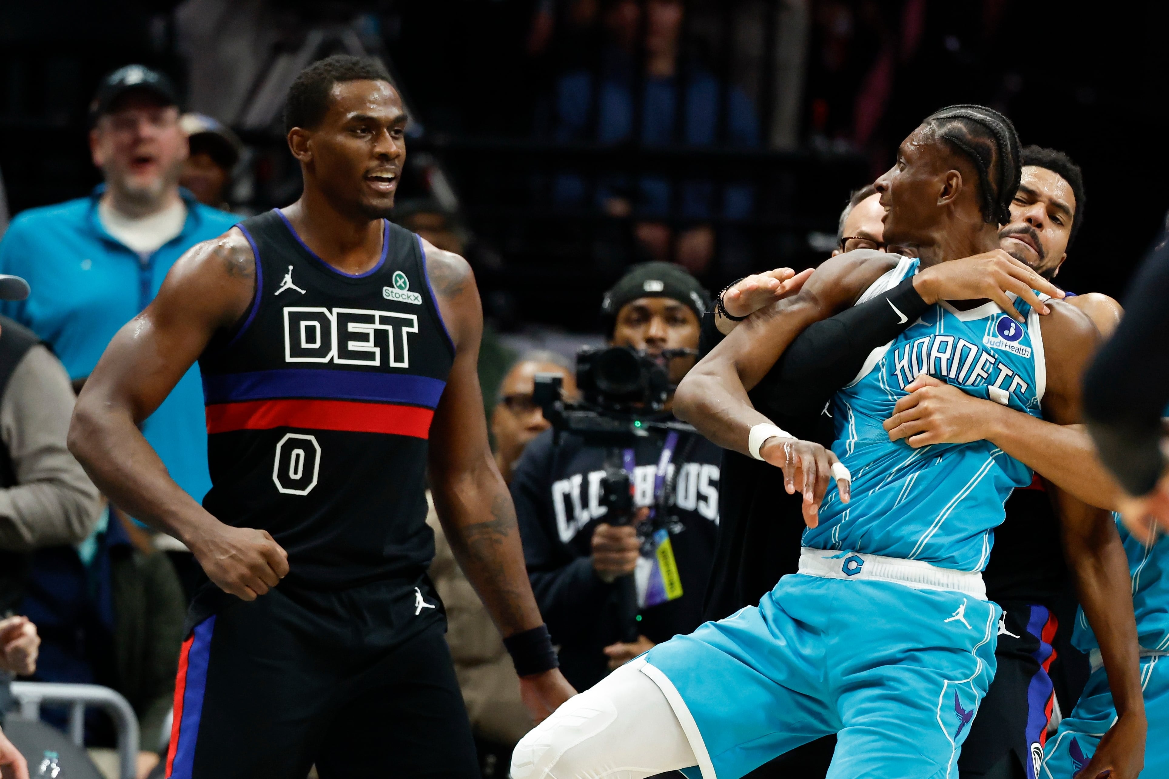 Charlotte Hornets forward Moussa Diabate, front right, is held back as he fights Detroit Pistons center Jalen Duren (0) on the court in the second half of an NBA basketball game in Charlotte, N.C., Monday, Feb. 9, 2026. (AP Photo/Nell Redmond)