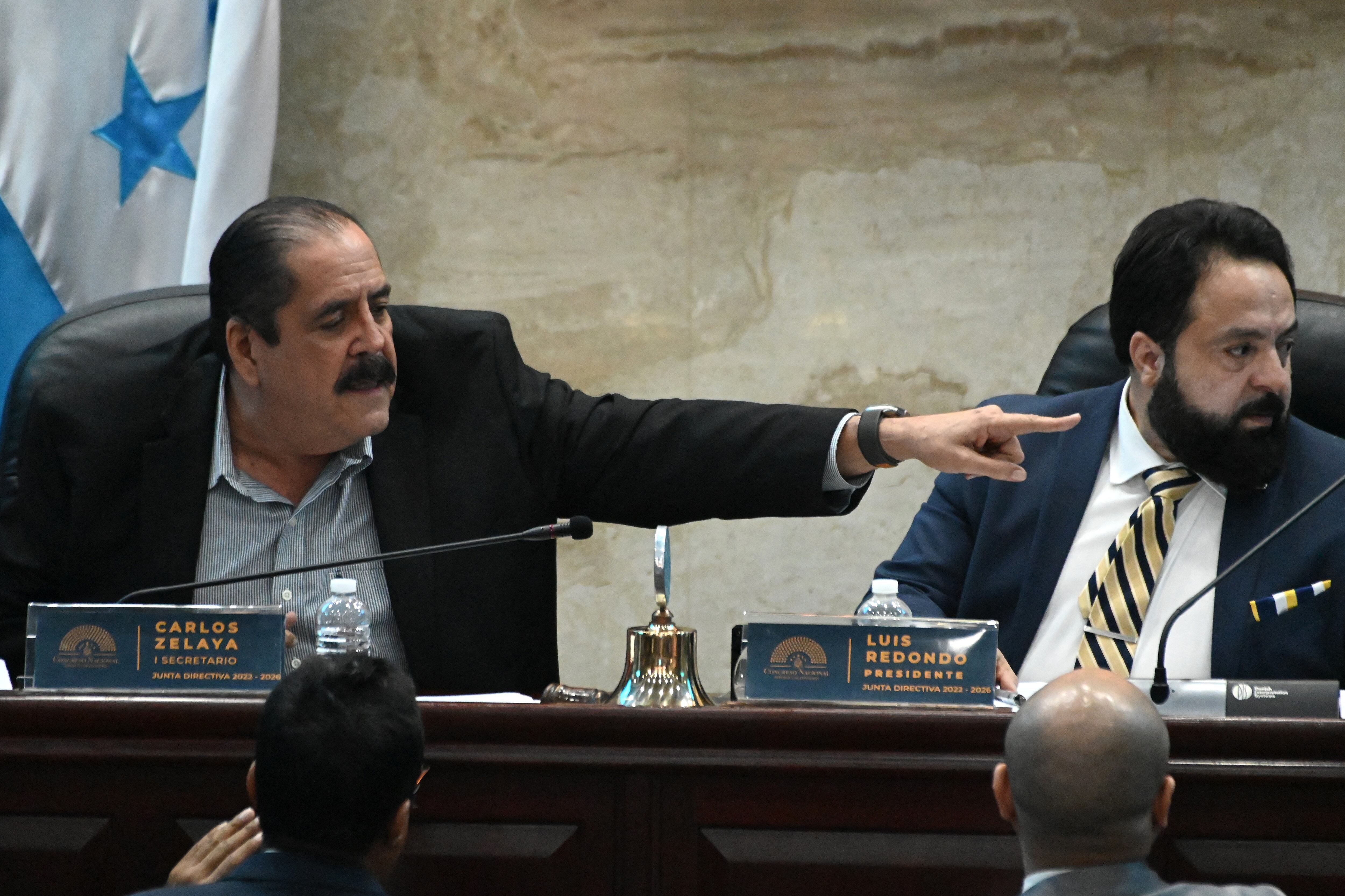 El secretario del Congreso de Honduras, Carlos Zelaya (izq.), hace un gesto junto al presidente del Congreso de Honduras, Luis Redondo, durante una sesión de la Cámara Legislativa en Tegucigalpa el 16 de enero de 2024.