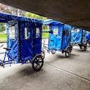 Triciclos azules junto a un puente peatonal en la calle en Bogotá Colombia bicitaxi