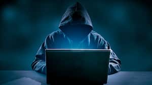 Pirata informático usando una computadora portátil. Muchos dígitos en la pantalla de la computadora.