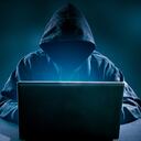 Pirata informático usando una computadora portátil. Muchos dígitos en la pantalla de la computadora.