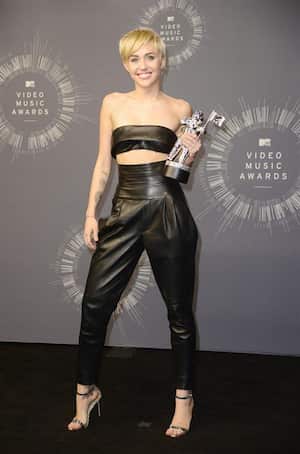 Miley Cirus también apostó por un total look en negro compuesto por pantalones y crop top. Muy elegante. Foto: EFE