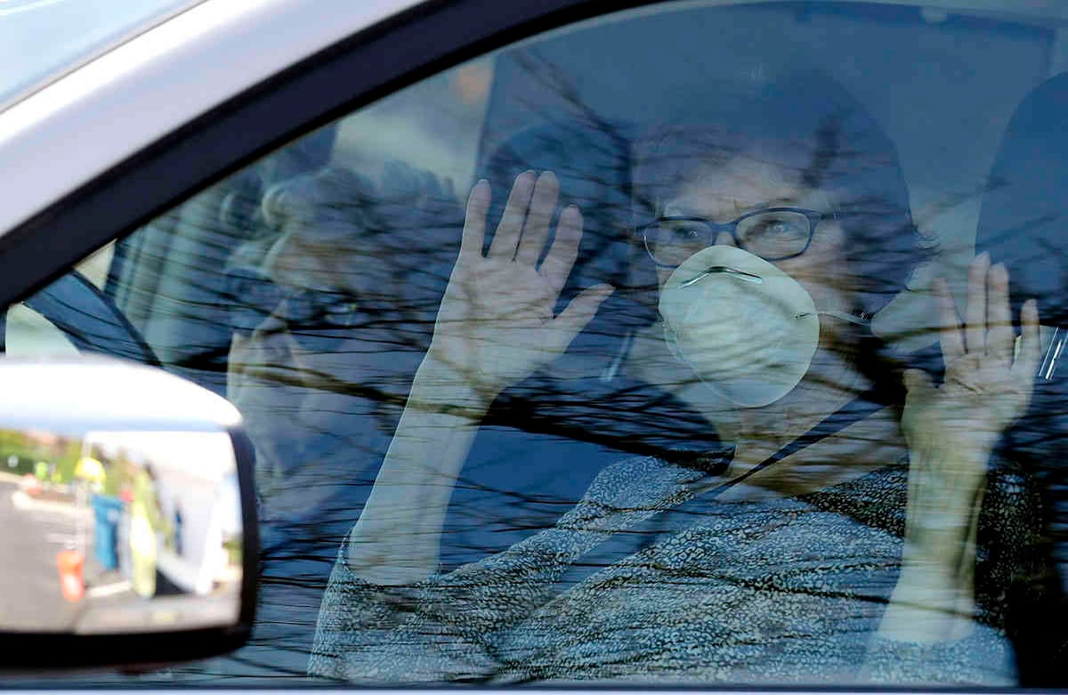 Residentes de Schaumburg  saludan.  En el pueblo se distribuyen 70,000 máscaras a los residentes de este suburbio del noroeste de Chicago mientras la pandemia del coronavirus continúa  (AP Foto / Nam Y. Huh)