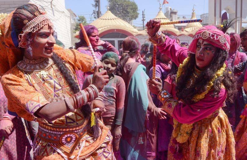 Artistas indios vestidos como Lord Krishna y Radha interpretan la danza folclórica tradicional "Dandiya Raas" durante las celebraciones del festival Holi en un templo en Amritsar. FOTO: NARINDER NANU / AFP.