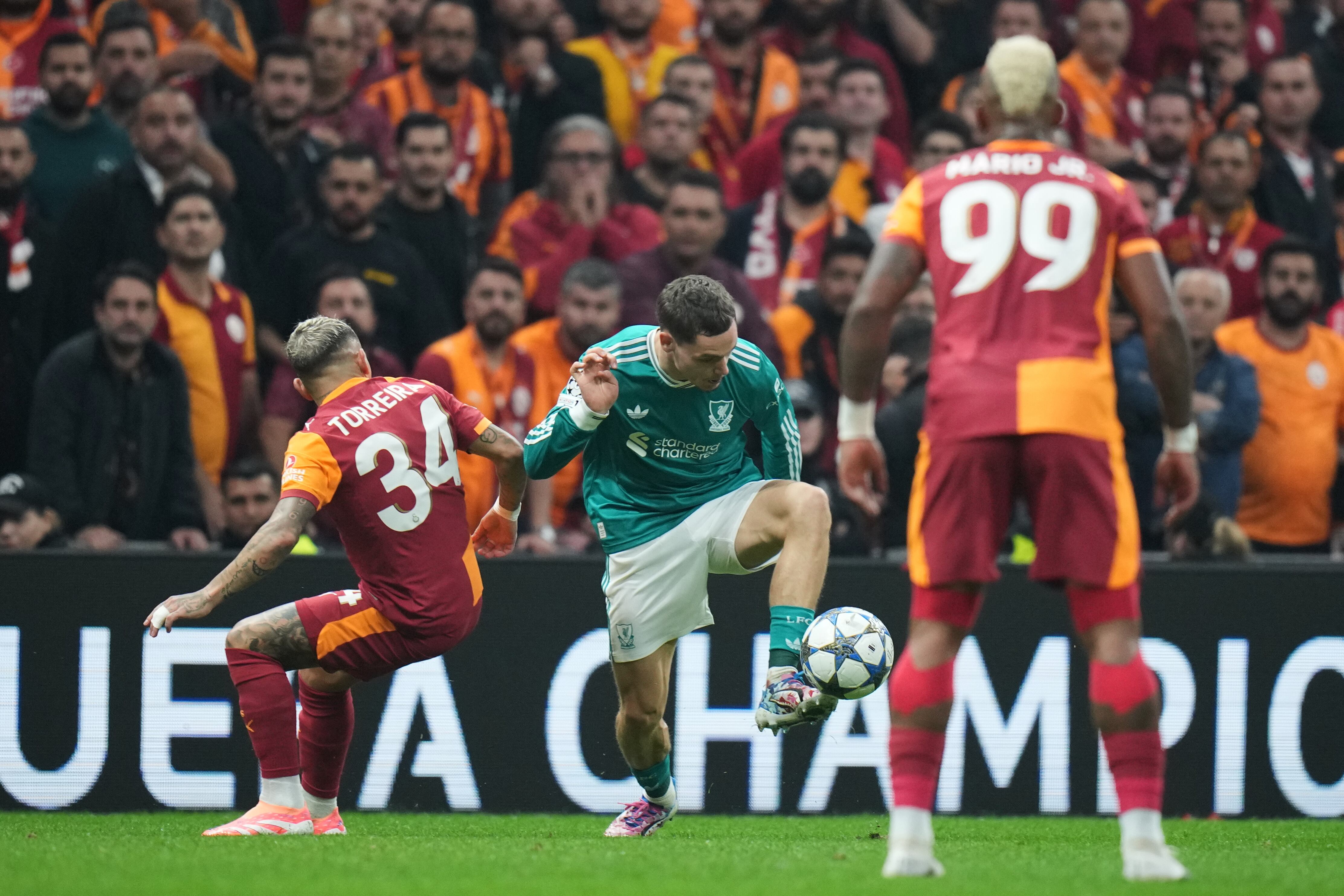 Liverpool's Florian Wirtz, center, fights for the ball with Galatasaray's Lucas Torreira, left, during the Champions League opening phase soccer match between Galatasaray and Liverpool at the Ali Sami Yen stadium, in Istanbul, Turkey, Tuesday, Sept. 30, 2025. (AP Photo/Francisco Seco)