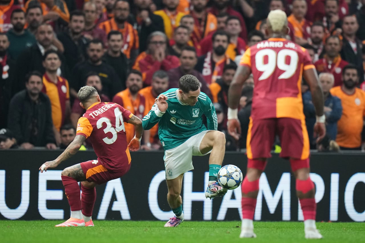 Liverpool's Florian Wirtz, center, fights for the ball with Galatasaray's Lucas Torreira, left, during the Champions League opening phase soccer match between Galatasaray and Liverpool at the Ali Sami Yen stadium, in Istanbul, Turkey, Tuesday, Sept. 30, 2025. (AP Photo/Francisco Seco)