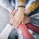 Cerrar vista superior de jóvenes empresarios juntando sus manos. Pila de manos. Concepto de unidad y trabajo en equipo.