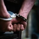 Man on the chair in Handcuffs. Rear view and Closeup ,Men criminal in handcuffs arrested for crimes. With hands in back,boy prison shackle in the jail violence concept.