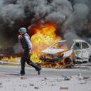 An Israeli firefighter walks next to cars hit by a missile fired from Gaza Strip, in the southern Israeli town of Ashkelon, Tuesday, May 11, 2021. (AP Photo/Ariel Schalit)