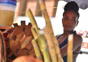 Una mujer vende jugo de caña de azúcar este jueves, un día antes de la conmemoración del Día Internacional de la Mujer, en Cali.