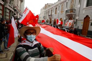 Supporters of presidential candidate Pedro Castillo celebrate partial election results outside his campaign headquarters in Lima, Peru, Monday, June 7, 2021, the day after the runoff election. (AP Photo/Guadalupe Pardo)