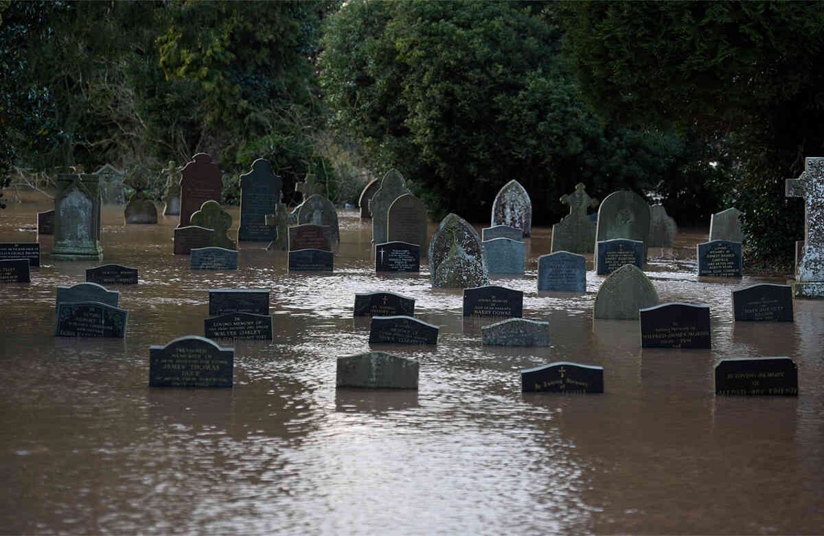 El agua rodea y cubre parte de las tumbas en un cementerio en Tenbury Wells, al oeste de Inglaterra, el 16 de febrero de 2020, luego de que la tormenta Dennis inundara grandes extensiones de Gran Bretaña. Un hombre murió después de caer en un río el domingo. Foto: Oli Scarff / AFP.