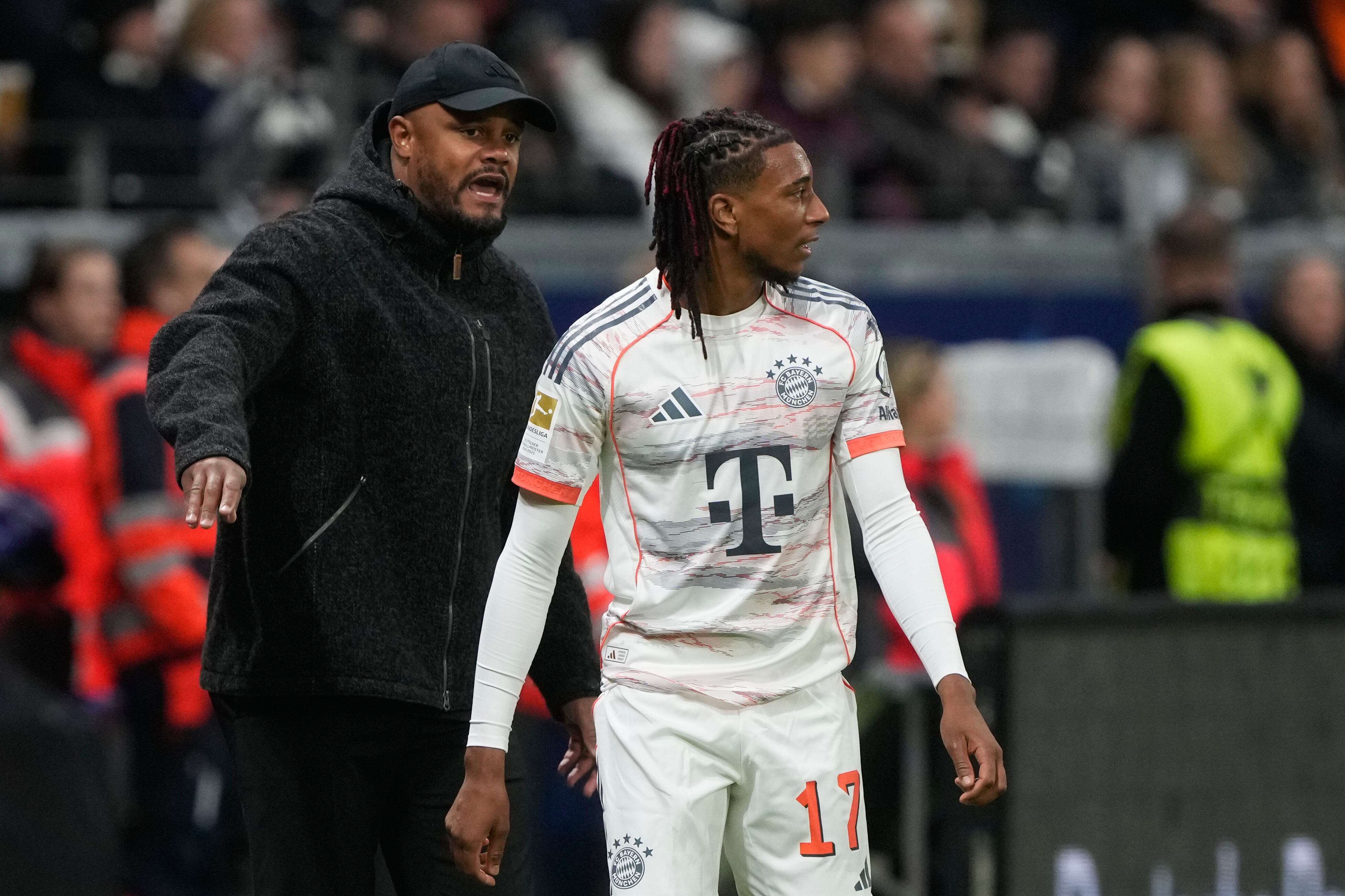 Bayern's head coach Vincent Kompany gestures behind Michael Olise during the Bundesliga soccer match between Eintracht Frankfurt and FC Bayern Munich in Frankfurt, Germany, Saturday, Oct. 4, 2025. (AP Photo/Michael Probst)