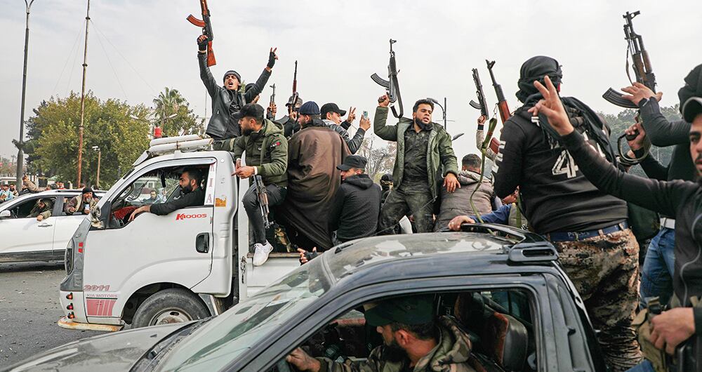 Tropas rebeldes en Damasco celebran tras la caída de Al Asad.