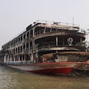 El ferrI quemado se ve anclado a lo largo de una costa un día después de que se incendió y mató al menos a 37 personas en Jhalkathi.